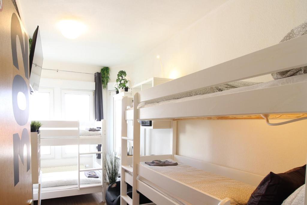 乌尔姆Hotel Ulm Zentrum - Komplettes Zimmer, Hochbett, Android TV & eigenem Bad - perfekt für Familien & Gruppen的一间卧室配有两张双层床。