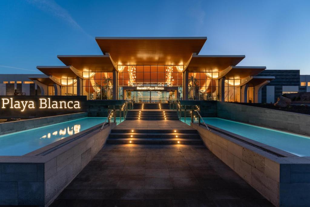 普拉亚布兰卡Barceló Playa Blanca的一座晚上设有游泳池的建筑