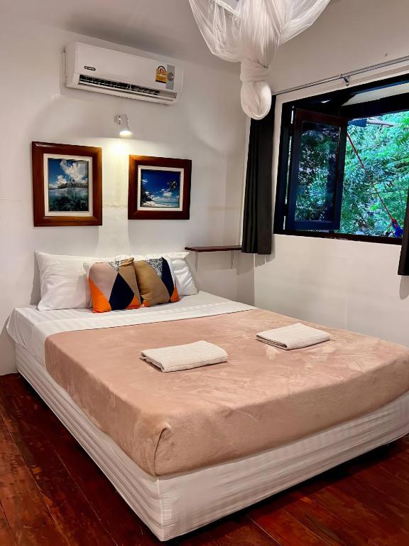 Haad TianKo Phangan Haad Yao Beach Hotel的一间卧室配有一张大床和两条毛巾