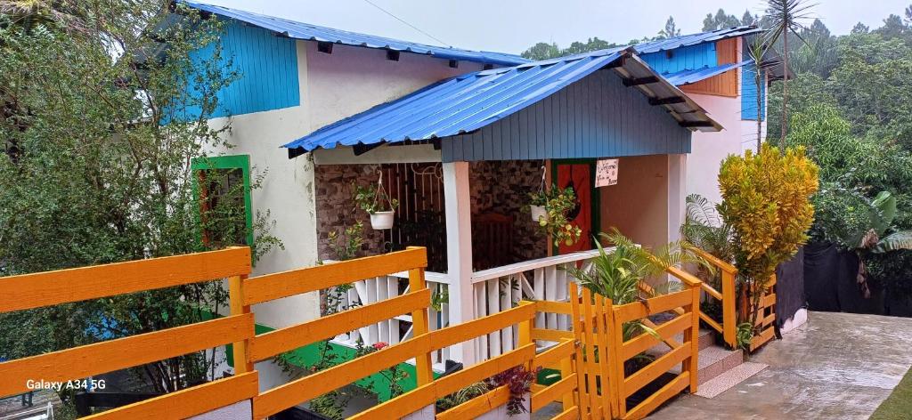 哈拉瓦科阿Cabaña Vistas del Bosque piscina privada的一座带栅栏和蓝色屋顶的房子