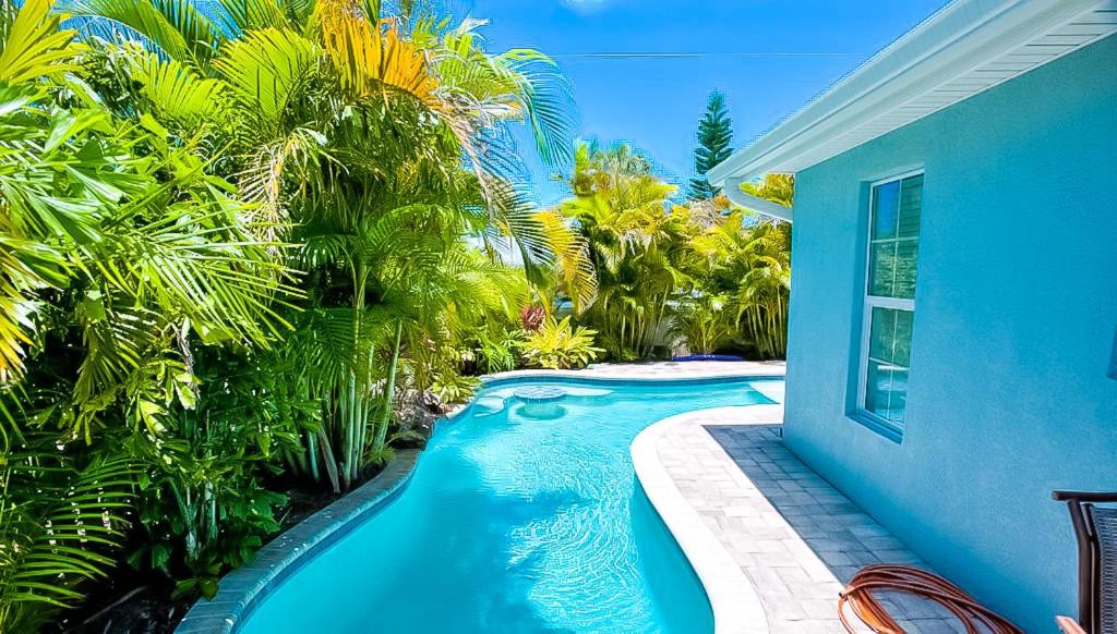 霍姆斯海滩Island Escape的蓝色房子前的游泳池