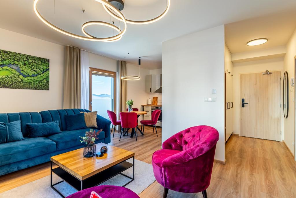 道尼库宾Apartmán na Kubínskej holi X33的客厅配有蓝色的沙发和粉红色的椅子