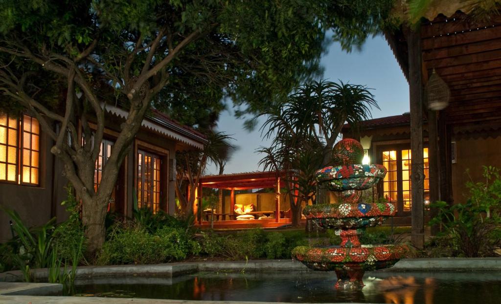 伊丽莎白港Singa Lodge - Lion Roars Hotels & Lodges的夜晚在房子前面的喷泉