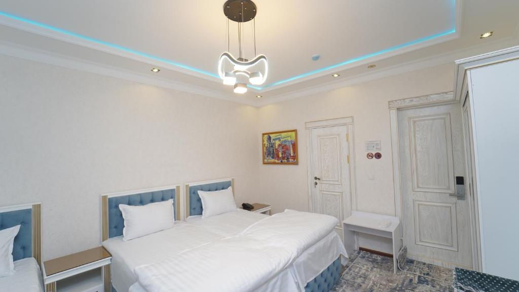 UzbankintyGulnora HOTEL的卧室配有2张白色的床和吊灯。