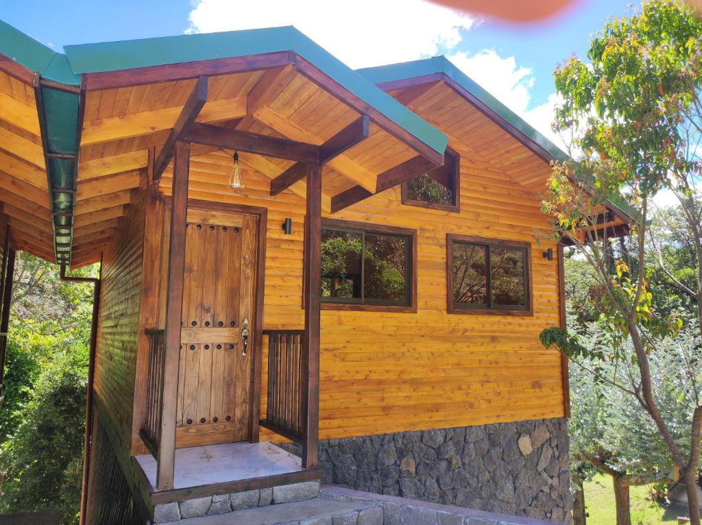 圣赫拉多德多塔Cabinas El Quetzal的一座带木门和屋顶的小房子