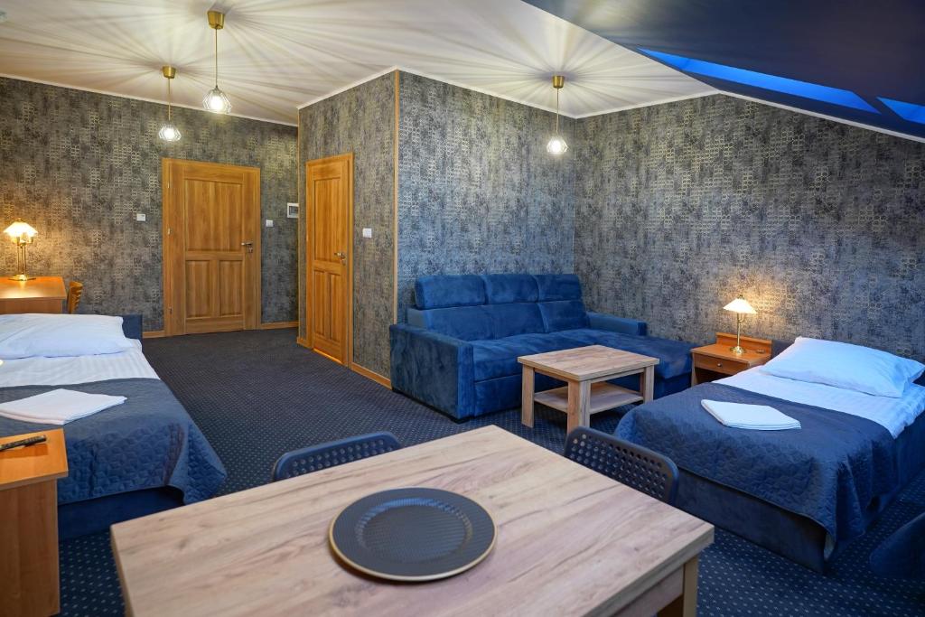 赫扎努夫Apartments ALKANTARA的客房设有两张床、一张沙发和一张桌子。