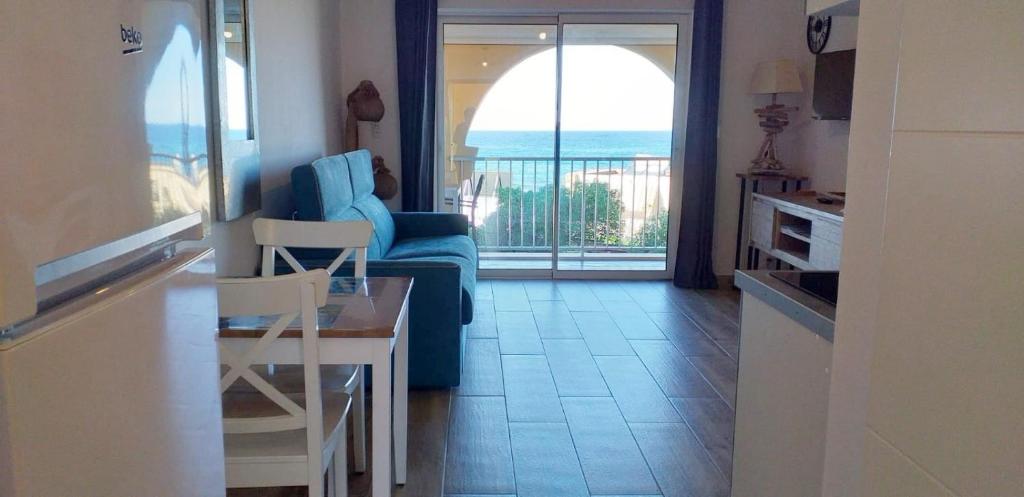 阿尔加约拉Studio standing classé avec terrasse vue mer " les pieds dans l'eau " à Algajola的客厅配有蓝色的沙发和桌子