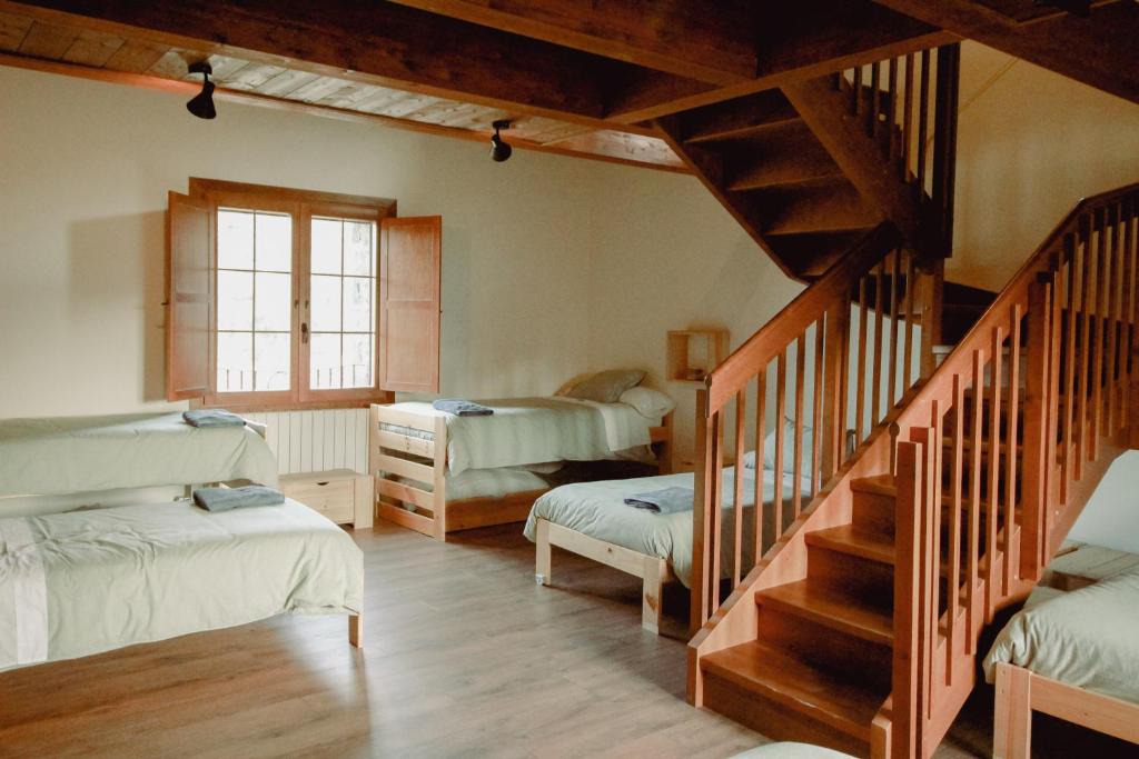 Casa Rural Ger的一间设有两张床的客房,房子里设有楼梯