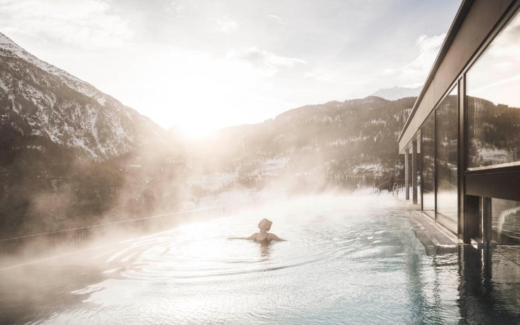索尔登Sportlers Lodge Sölden lifestyle-lässig-anders的在山底热水浴池中游泳的人