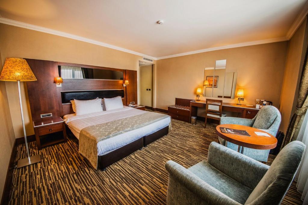 安卡拉OttomanHotel的酒店客房,配有一张床、一张桌子和椅子