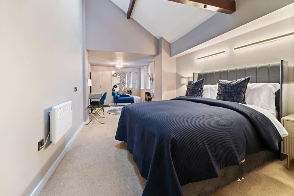 莱斯特NEW Large luxurious 2 bed city penthouse + parking的一间卧室配有一张带蓝色毯子的大床