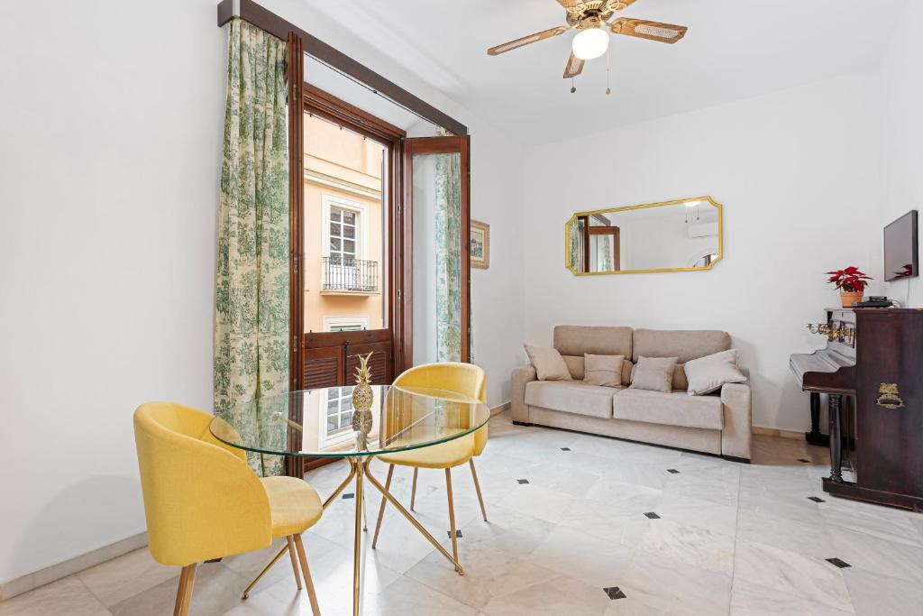 马拉加Pineapple Trinidad Grund Centro的客厅配有玻璃桌和黄色椅子