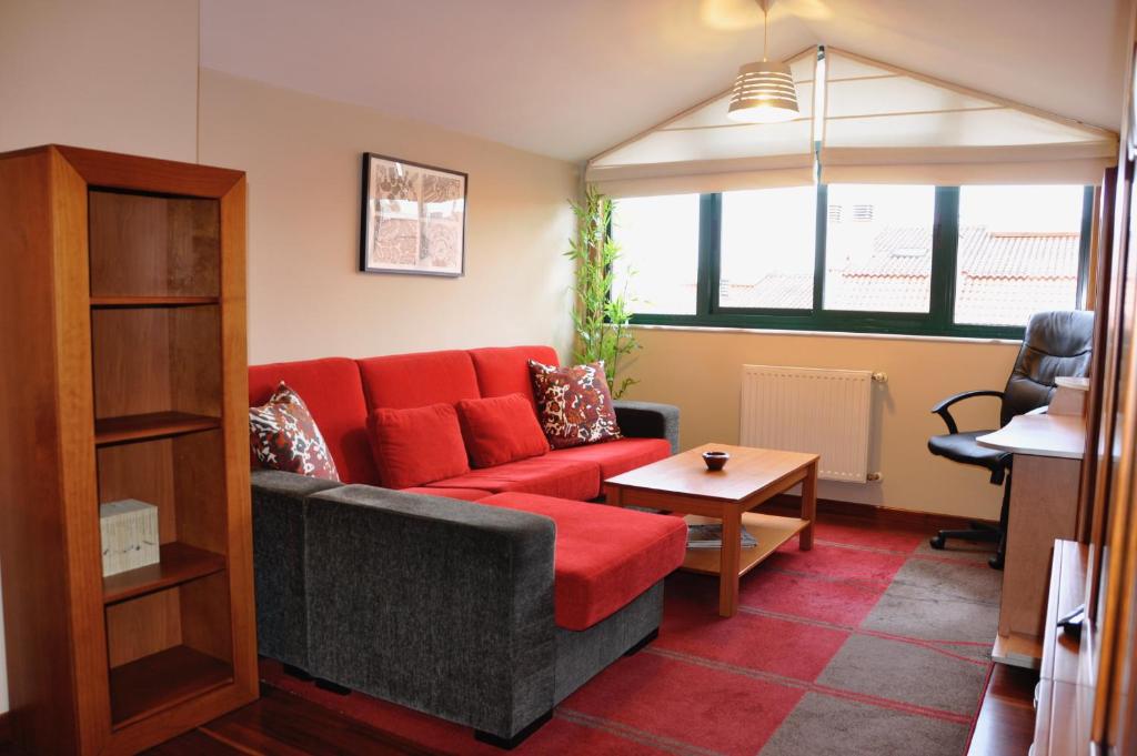 米拉多罗Alojamiento Santa Maria III的客厅配有红色的沙发和桌子