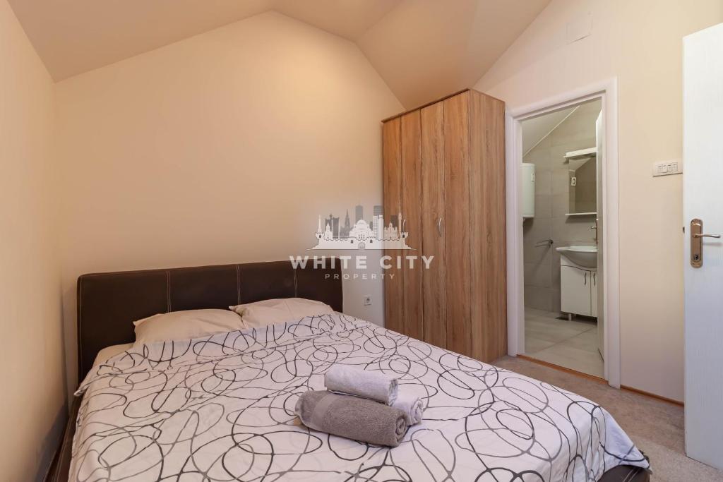 贝尔格莱德Townhouse - WHITE CITY Apartments的一间带大床的卧室和一间浴室