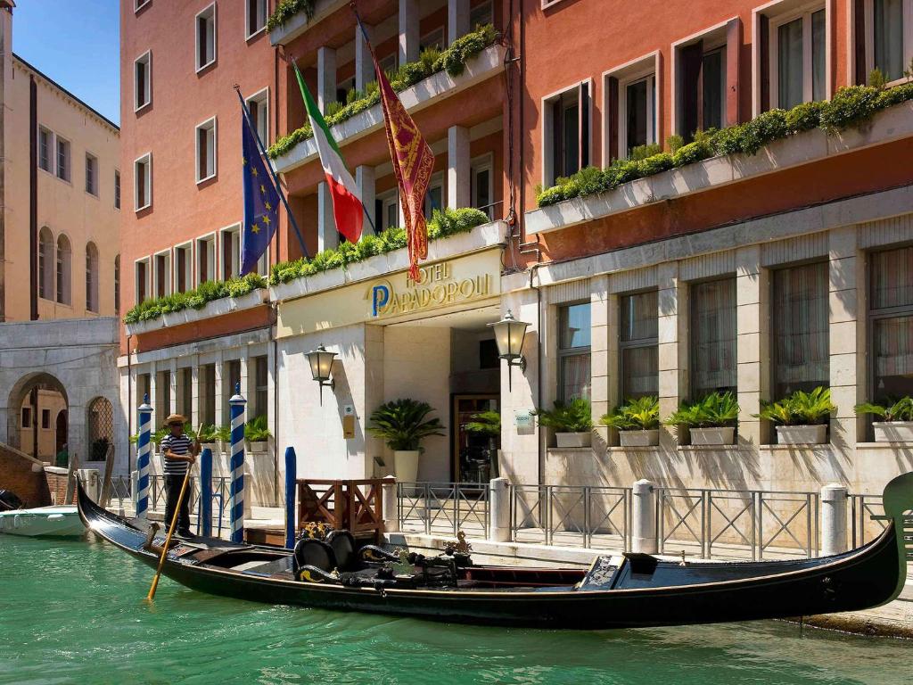 威尼斯Hotel Papadopoli Venezia - MGallery Collection的建筑物前水中的空中缆车