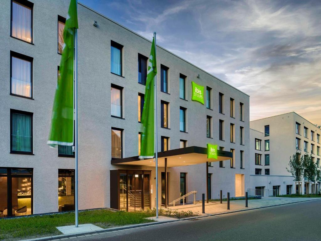 腓特烈港ibis Styles Friedrichshafen的前面有绿色旗帜的建筑