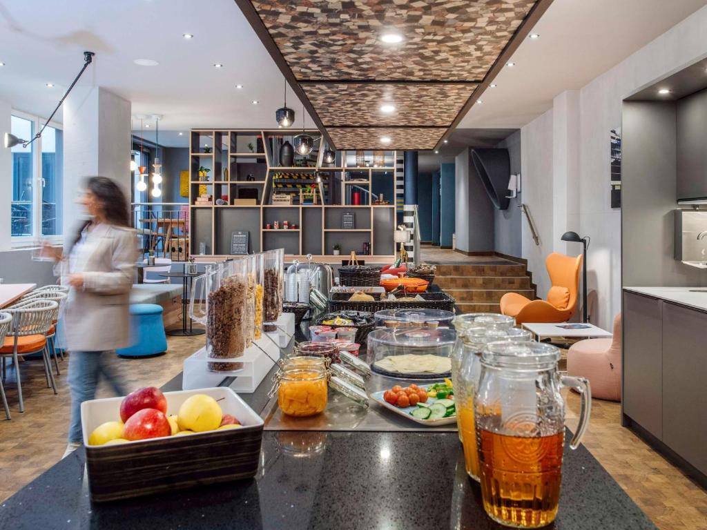 汉堡Aparthotel Adagio access Hamburg的站在厨房里,在柜台上吃食物的女人