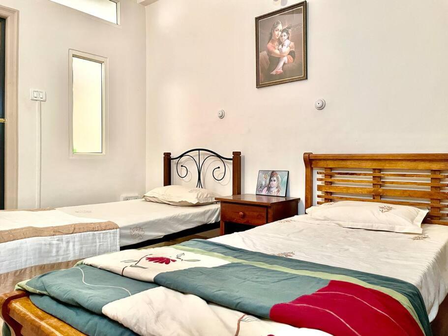 普塔帕蒂Shanthi Home Stay的一间卧室配有两张床、一张桌子和一面镜子