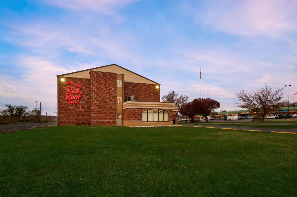 马丁斯堡Red Roof Inn Martinsburg的建筑物的侧面有停车标志