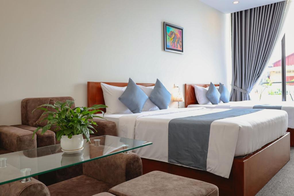 金边Nimith Hotel & Restaurant的酒店客房设有一张床铺和一张玻璃桌