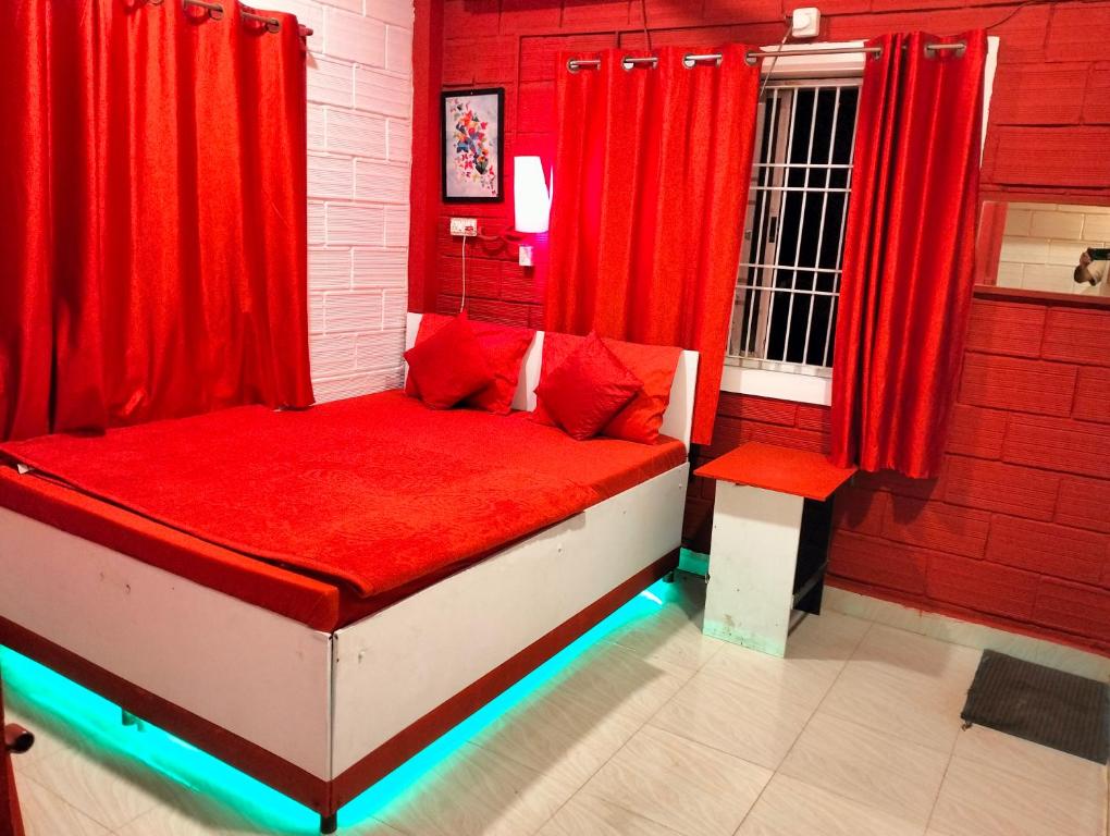戈卡尔纳Greenland gokarna Ac and Non Ac的红色的房间,配有红色窗帘的床