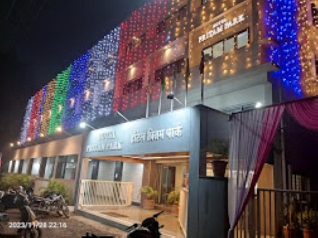 JālgaonHOTEL PRITAM PARK, Jalgaon, Maharashtra的建筑的侧面有五颜六色的灯光