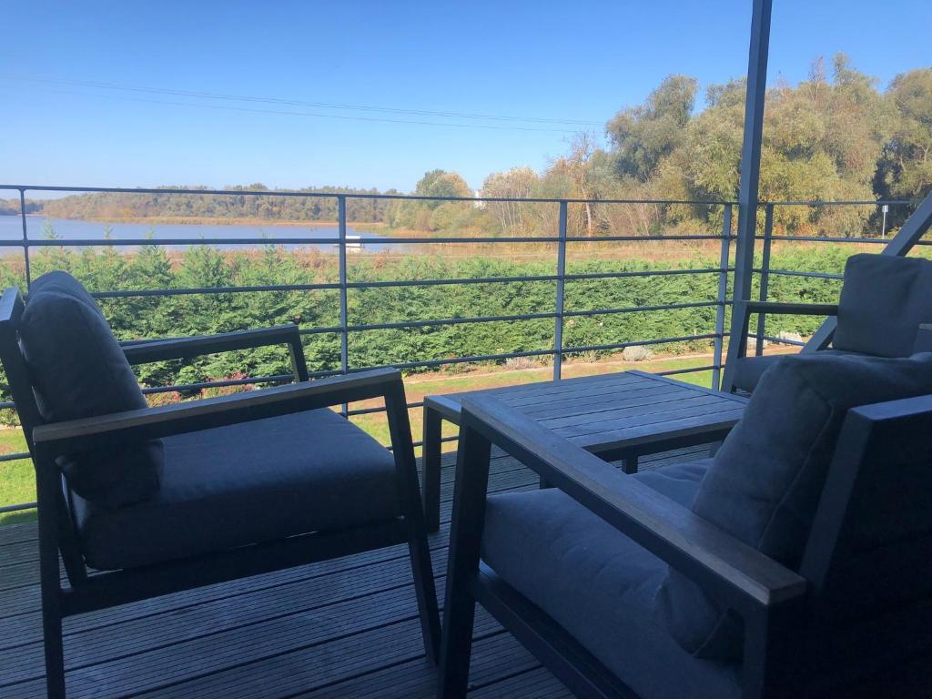 蒂萨菲赖德OpusTisza7 Apartman的甲板上配有两把椅子和一张桌子,享有田野的景色