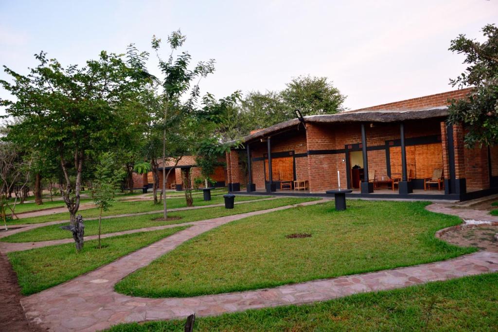 MfuweKUDU SAFARI LODGE (Mfuwe, Zambia)的公园里带走道的砖砌建筑