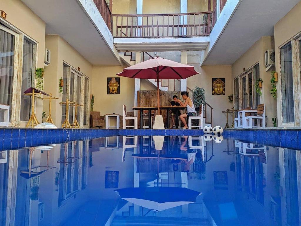 吉利特拉旺安格林拉浪旅馆的坐在游泳池旁的伞下,一对夫妇