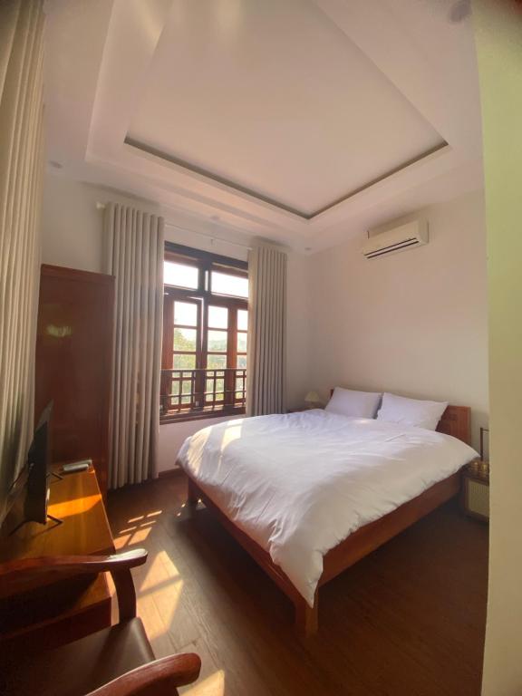 Bắc QuangCao Son Hotel的卧室设有一张白色大床和一扇窗户。