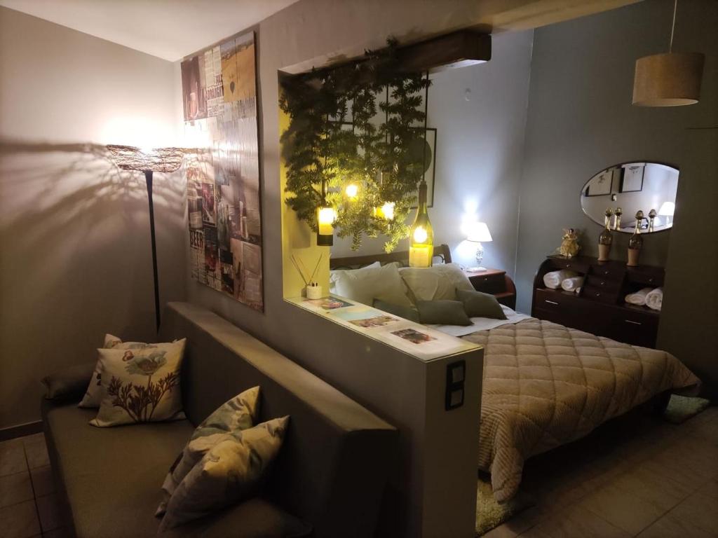新基奥斯Wine Reflections Apartment near Nafplio的一间卧室配有一张床、一张桌子和一张沙发