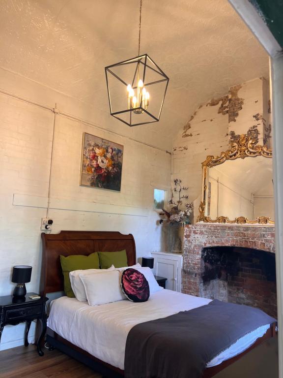 巴瑟斯特The Tamarisks at Rosevale的一间卧室配有一张带壁炉和镜子的床