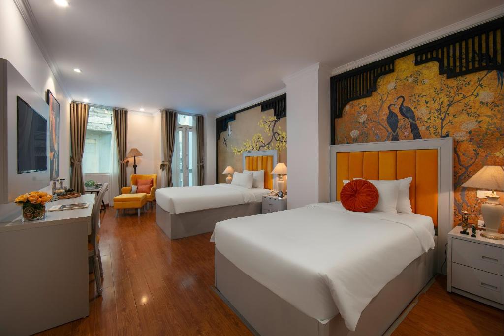 河内San Hanoi Hotel的酒店客房带两张床、书桌以及一间客房。