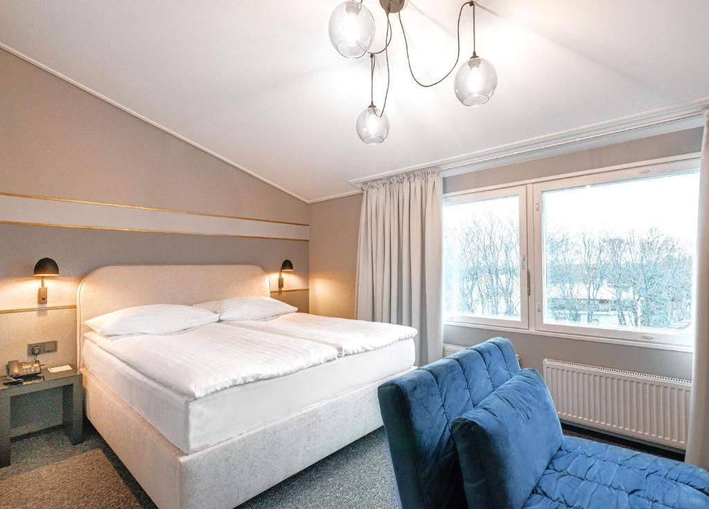 塔林Rija Fonnental Design Hotel Tallinn的卧室配有白色的床和蓝色椅子