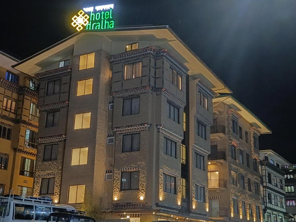 廷布Hotel Dralha的上面有 ⁇ 虹灯标志的建筑