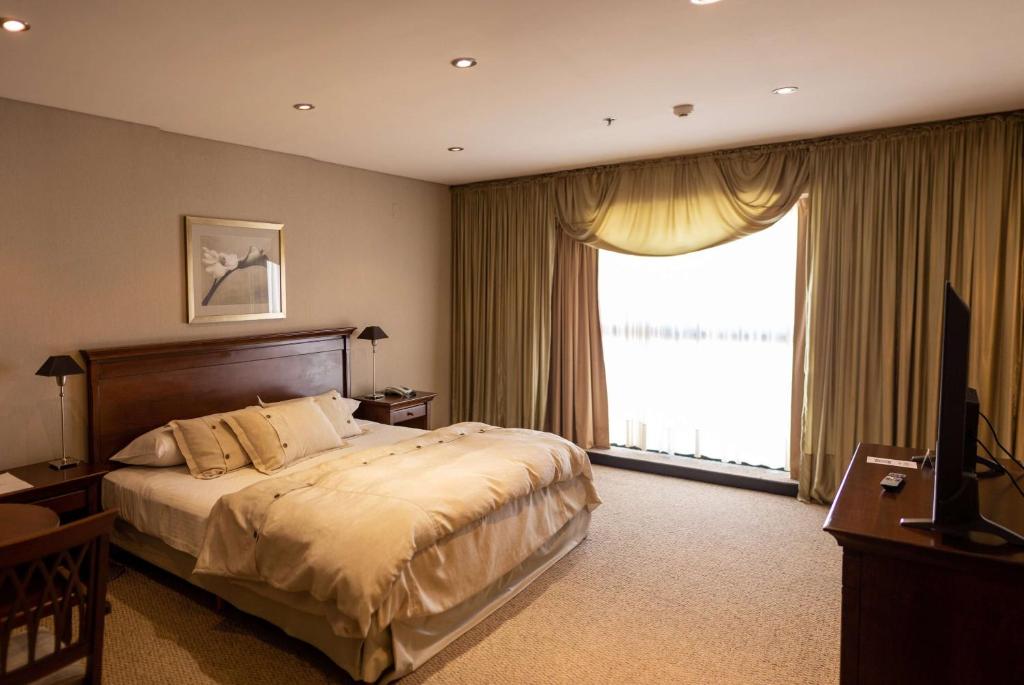 圣萨尔瓦多德朱胡胡伊豪生大酒店的一间卧室设有一张大床和一个大窗户