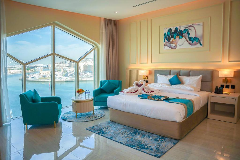 迪拜Concorde Creek View Hotel Bur Dubai的一间卧室配有一张床和两张蓝色椅子