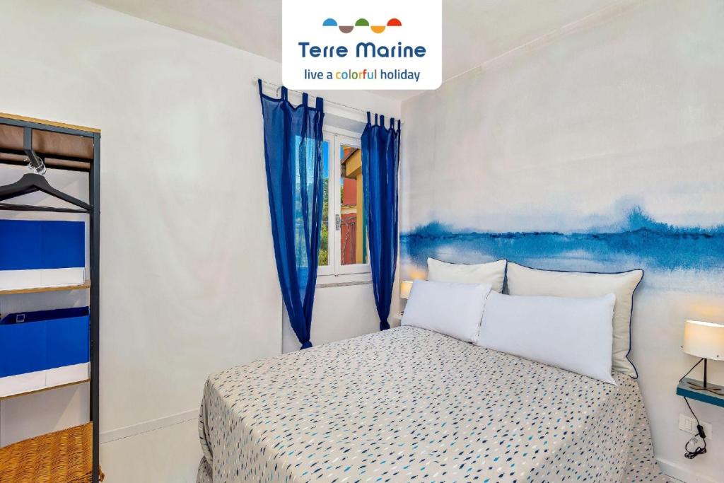 费扎诺Casa Bianca, TerreMarine的卧室配有一张床,墙上挂着一幅蓝色画作