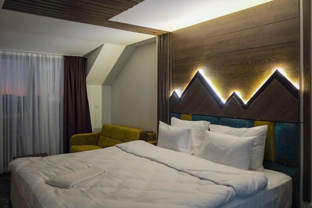 科帕奥尼克Harmonija Resort - Harmonia Palace的一间卧室配有一张大床和木制床头板
