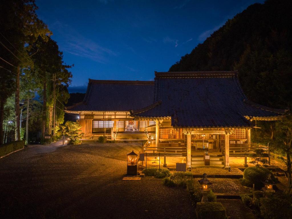 Shimosato宿坊 大泰寺 Temple Hotel Daitai-ji的一座大型木结构建筑,晚上有屋顶