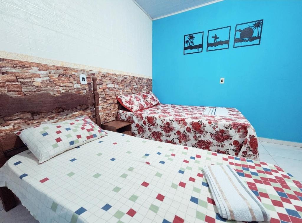 瓜拉派瑞Pousada Dule的卧室配有床和床,铺有四柱床。
