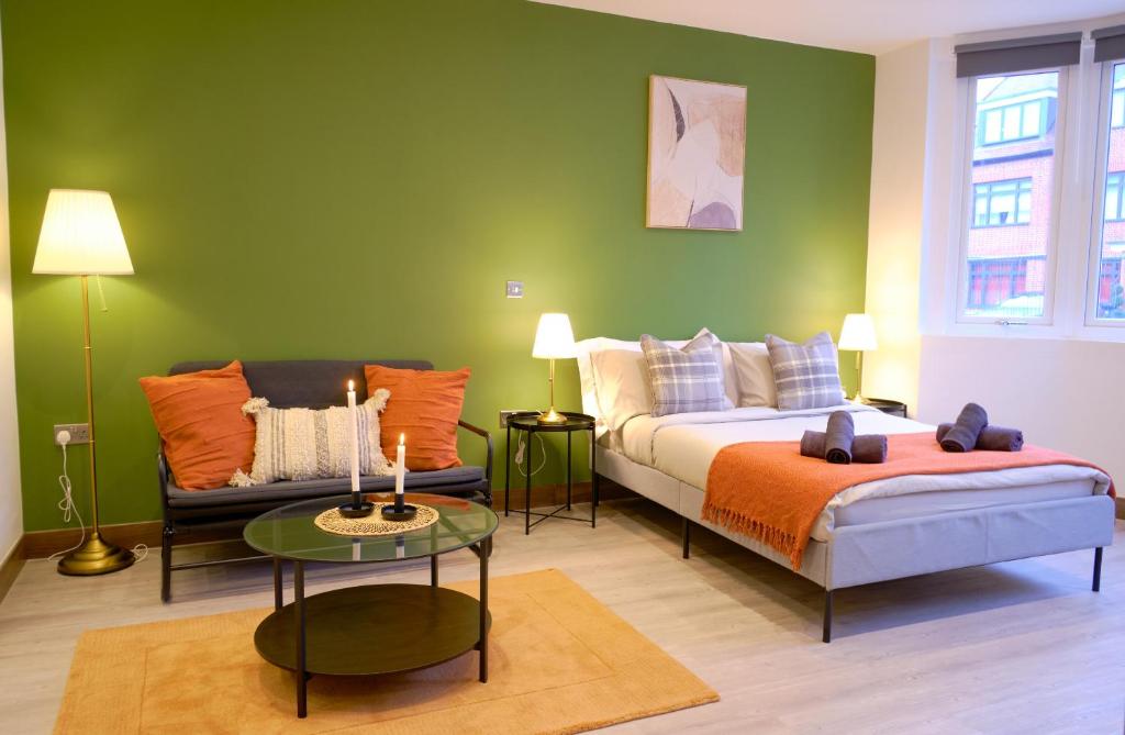 伦敦GoldersGreen Apartments by Sleepy的一间卧室配有一张床、一张沙发和一张桌子