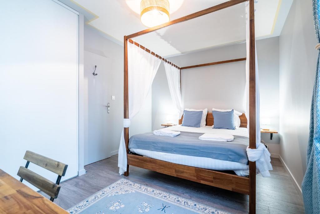 里摩日Mon Appart'hôtel - Gare de Limoges - Charmant 1 et 2 Chambres Duplex - Parking en supp的一间卧室配有一张天蓬床、蓝色床单和枕头