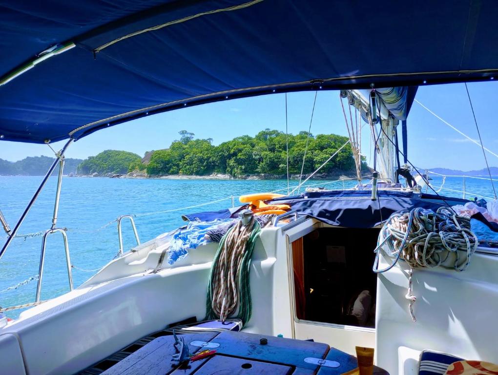 安格拉杜斯雷斯Paseos en Velero en Angra dos Reis的一条在水面上带有蓝色天篷的船
