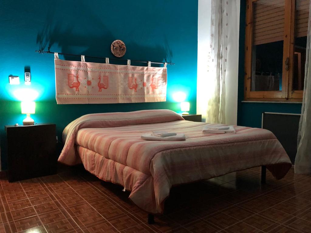 AlesB&B Daddanca的一间卧室配有一张蓝色墙壁的床和两盏灯。