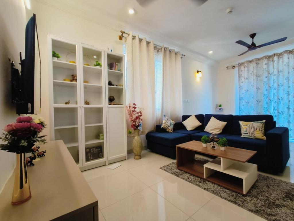 班加罗尔Anvaya Tranquility的客厅配有蓝色的沙发和桌子