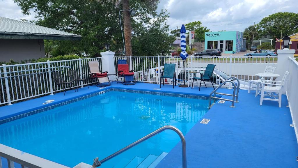 圣奥古斯丁Historic Inn - Saint Augustine的蓝色的游泳池配有椅子和桌子
