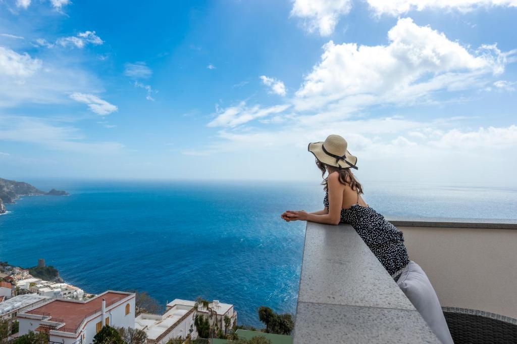 普莱伊亚诺Albadamare Boutique Hotel的坐在领海的女人,看着大海