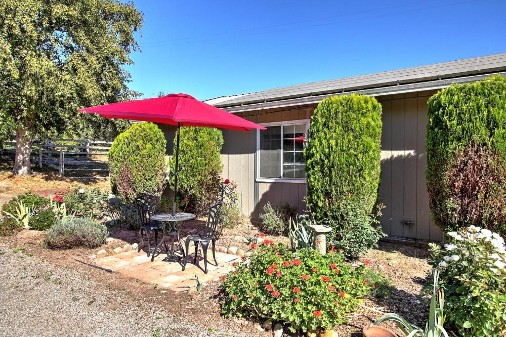 比尔顿Wine Country Ranch Escape的一个带桌子和红色遮阳伞的庭院