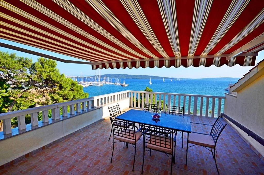 卡什泰拉Apartment Luxury Cream的阳台配有桌椅,享有水景